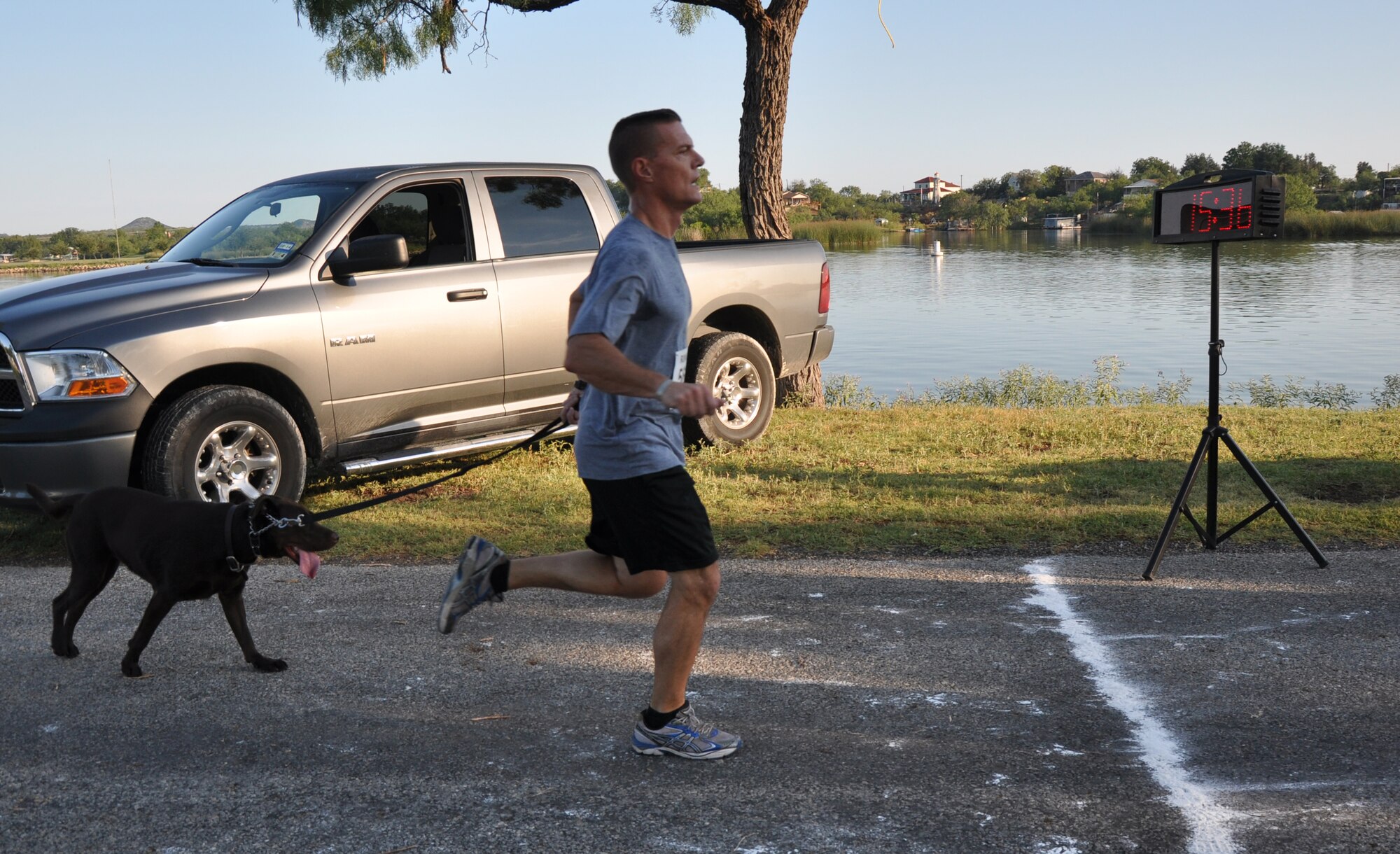 SAN ANGELO, Texas –Col. Brendan Harris, 17th Training Group Commander, and his dog Chief finish the Armydillo two-mile fun run at the 19th Annual Armydillo at the Spring Creek Marina and RV Park Aug. 24. Col. Harris and Chief finished the run with a time of 15 minutes and 37 seconds. (U.S. Air Force photo/ Airman 1st Class Joshua Edwards))