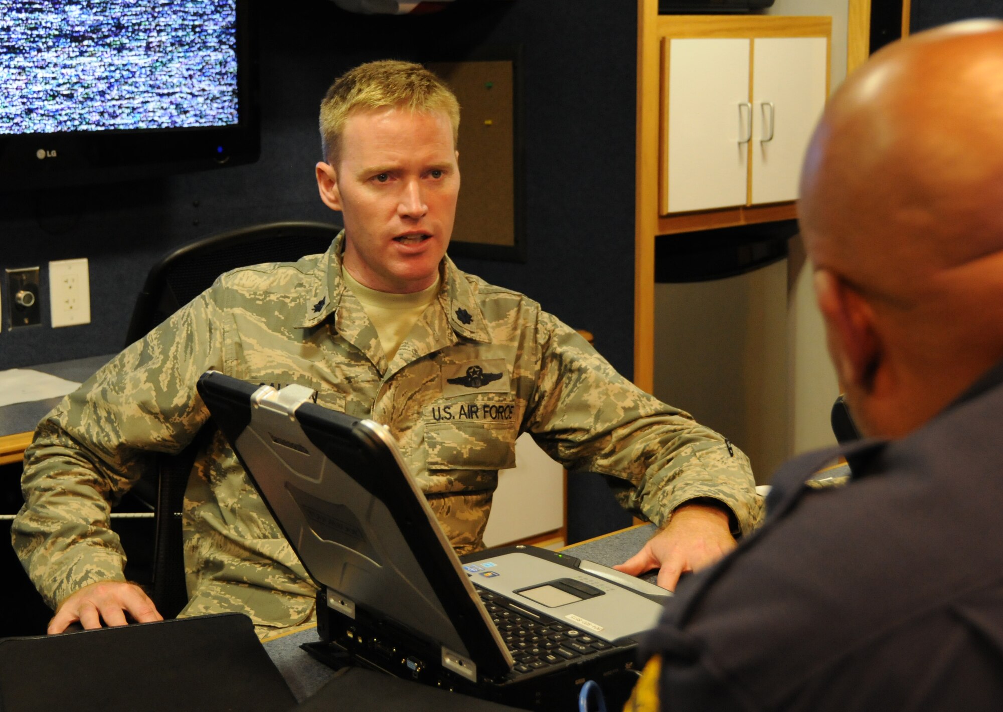 Lt. Col. Bryan Salmon, 192nd Intelligence Commander, talks about the video feed with Sergeant First Class Ray Newby, Virginia State Police, during a domestic operations exercise 21 August. (U.S. Air National Guard photo by Master Sgt. Carlos Claudio/Released). 