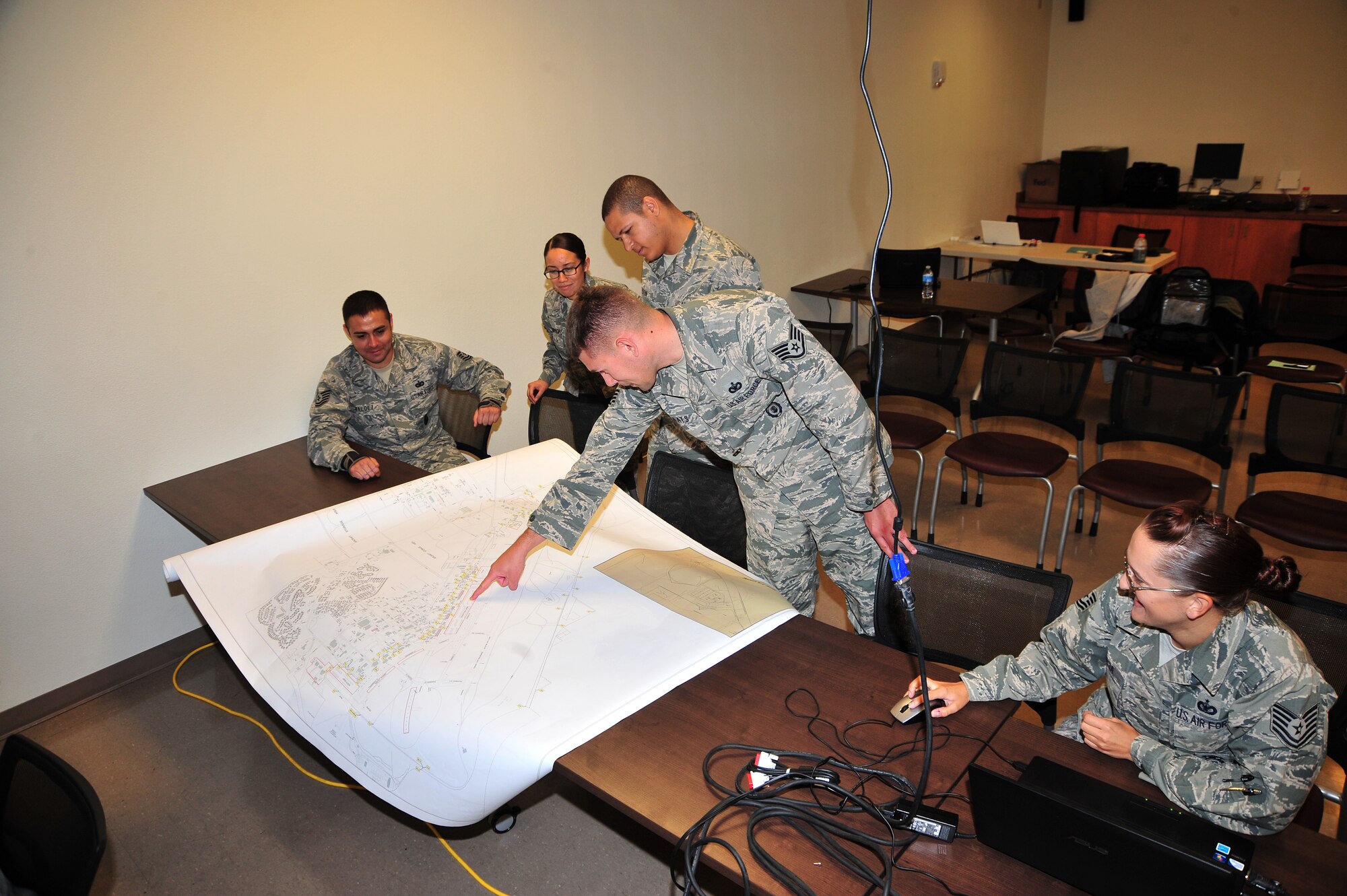 A group of subject matter experts gather together to look at a base map at Davis-Monthan Air Force Base, Ariz., August 14, 2013. The SMEs are working on ways to enhance security for base assets.(U.S. Air Force photo by Airman 1st Class Josh Slavin/Released)