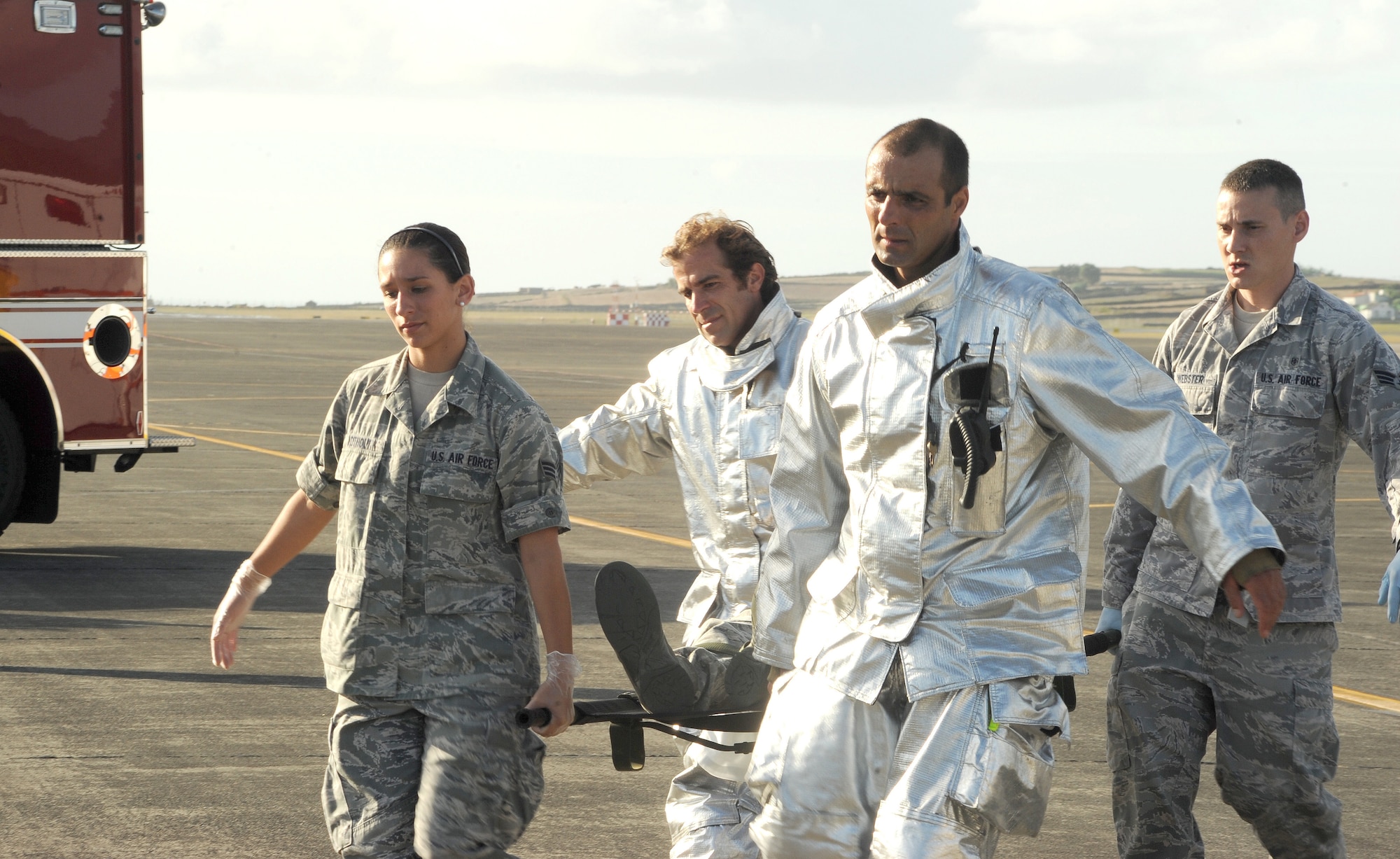 Airmen from the 65th Air Base Wing and Portuguese Air Force carry a mock victim to an ambulance during a major accident response exercise Aug. 23, 2013, at Lajes Field, Azores.  The exercise tested the ability of the U.S. and Portuguese Air Force to respond jointly in the event of an aircraft accident.   (U.S. Air Force photo by Guido Melo/Released)