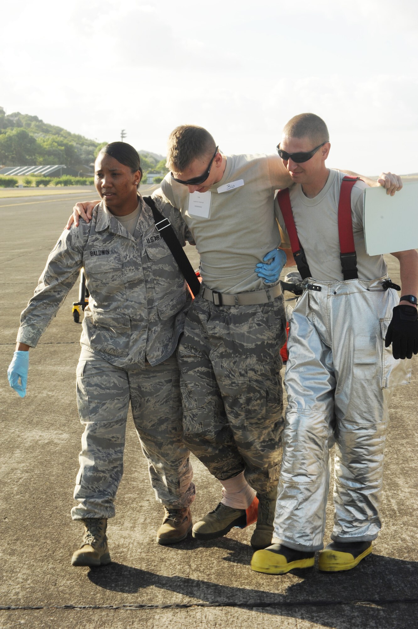 U.S. Air Force Staff Sgt. Yvette Baldwin, left, 65th Medical Operations Squadron medical technician, and Tech. Sgt. Jared Dudden, 65th Civil Engineer Squadron firefighter, assist a mock victim during a major accident response exercise Aug. 23, 2013, at Lajes Field, Azores.  The exercise tested the ability of the U.S. and Portuguese Air Force to respond jointly in the event of an aircraft accident.   (U.S. Air Force photo by Guido Melo/Released)