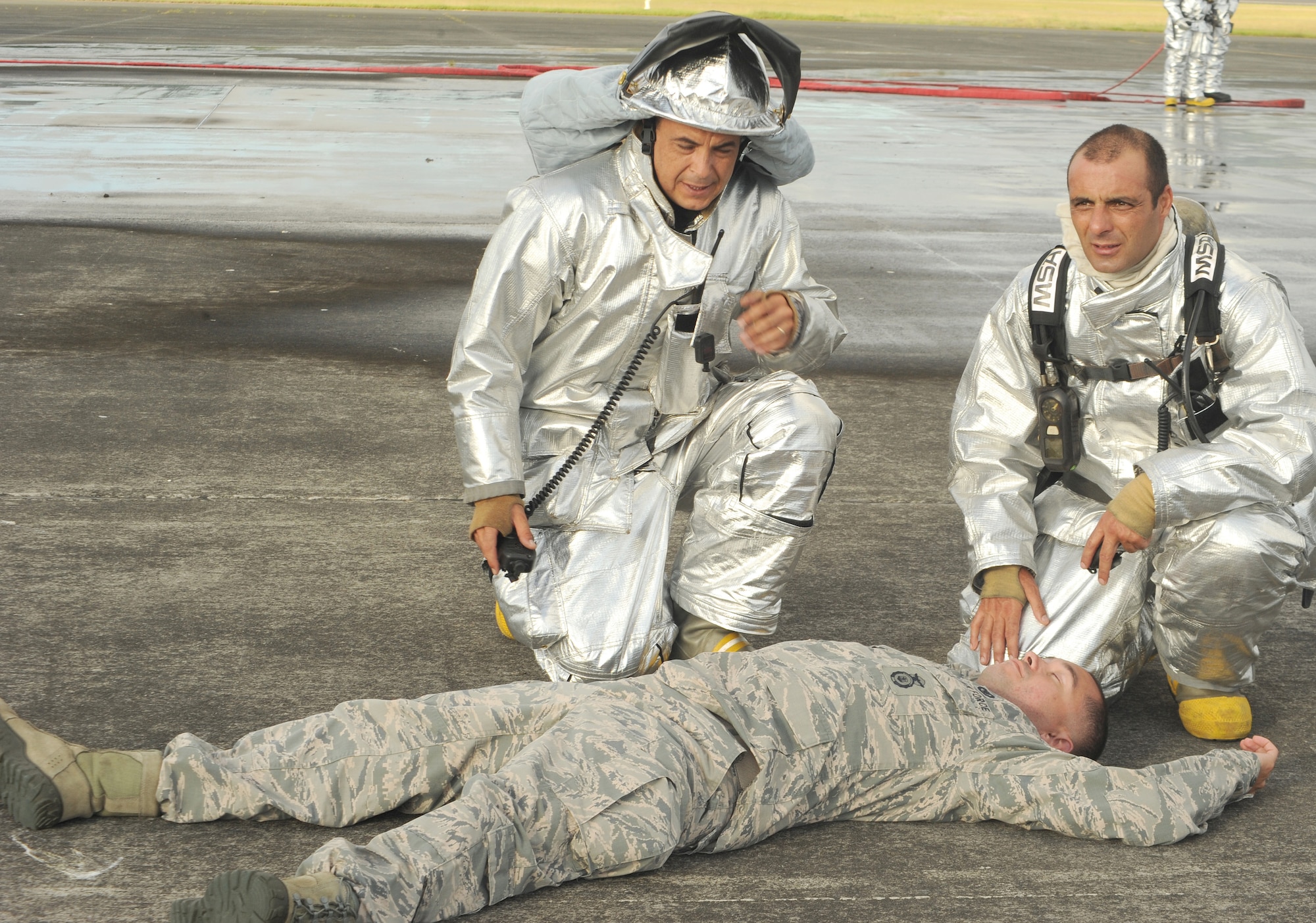 U.S. Air Force personnel Paulo Veredes and Rui Chavier, 65th Civil Engineer Squadron firefighters, give first aid to a mock victim during a major accident response exercise Aug. 23, 2013, at Lajes Field, Azores.  The exercise tested the ability of the U.S. and Portuguese Air Force to respond jointly in the event of an aircraft accident.   (U.S. Air Force photo by Guido Melo/Released)