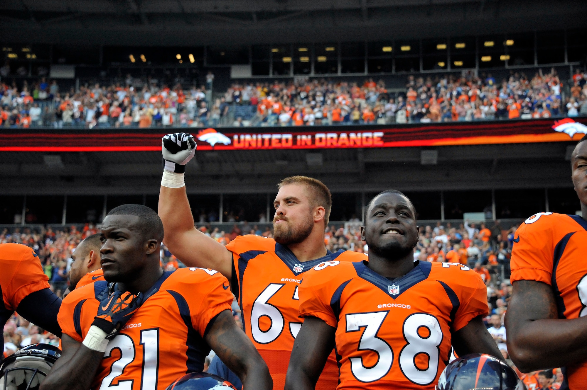 Air National Guard 1st Lt. Benjamin Garland (63), Denver Broncos Offensive Guard and 140th Wing Public Affairs Officer, stands with Ronnie Hillman (21) and Montee Ball (38) as he pumps his fist in the air after the National Anthem at Sports Authority Field at Mile High Stadium, Denver, Colo. Aug 24, 2013. Garland, who originally entered the National Football League in 2010 after graduating from the U.S. Air Force Academy, was on the Bronco’s reserve/military list while fulfilling his active duty obligations in the Air Force. In 2012 Garland joined the Colorado Air National Guard and made the Broncos practice squad as a defensive lineman and is competing this season to make the 53 man final roster. (Air National Guard photo by Tech. Sgt. Wolfram M. Stumpf)