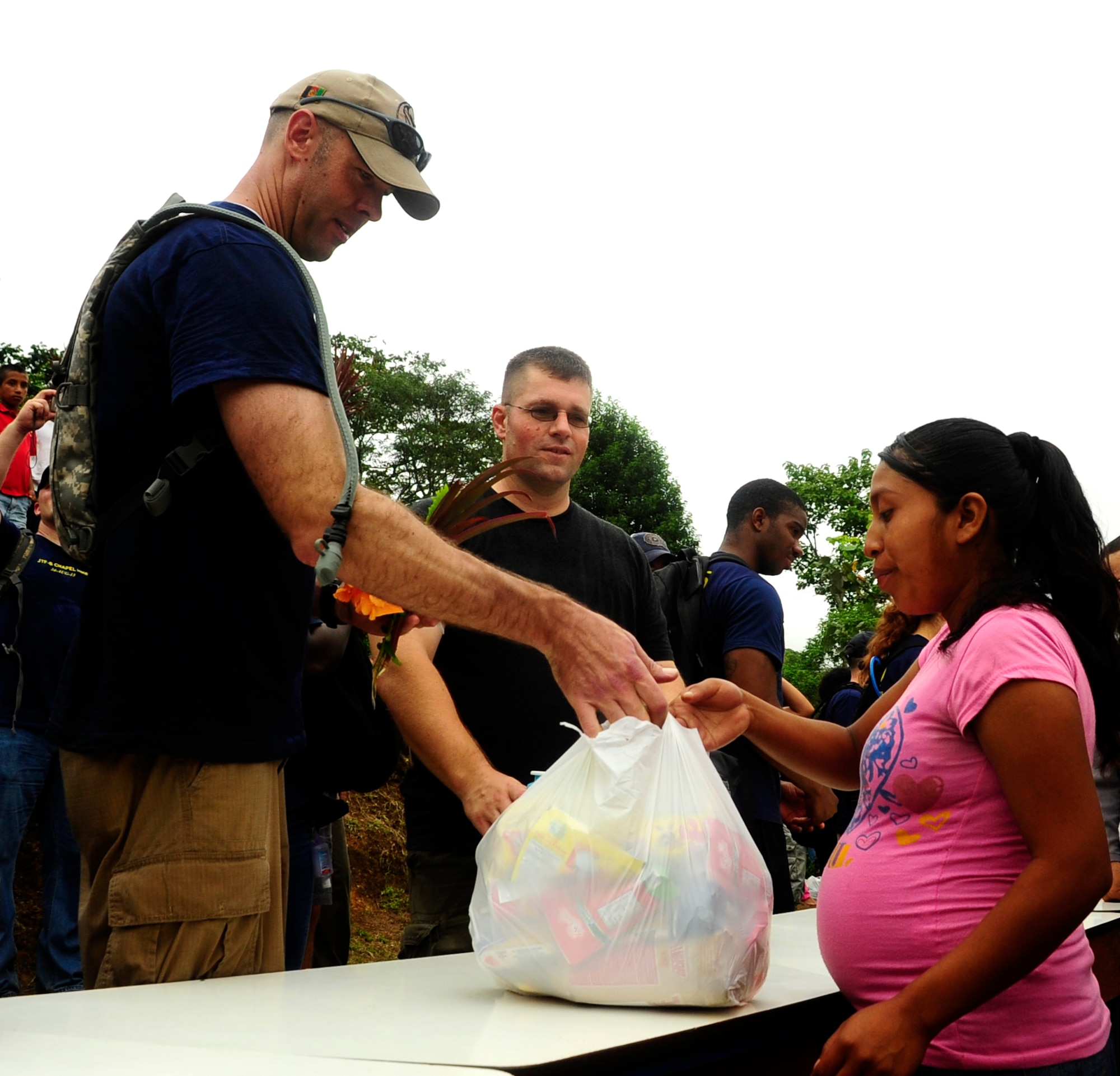 U.S. Air Force Maj. Robert Shaw, Joint Task Force-Bravo’s Joint Security Forces commander, provides essential groceries and hygiene products to a villager living on top of the mountain Aldea Bella Vista, during the 50th Chapel Hike, Aug 24, 2013. The Chapel Hike has been a tradition at Joint Task Force-Bravo since 2007, where volunteers carry food, supplies, toys and other provisions to remote villagers. (Photograph released by U.S. Air Force Staff Sgt. Jarrod Chavana)