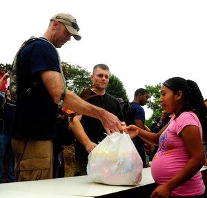 U.S. Air Force Maj. Robert Shaw, Joint Task Force-Bravo’s Joint Security Forces commander, provides essential groceries and hygiene products to a villager living on top of the mountain Aldea Bella Vista, during the 50th Chapel Hike, Aug 24, 2013. The Chapel Hike has been a tradition at Joint Task Force-Bravo since 2007, where volunteers carry food, supplies, toys and other provisions to remote villagers. (Photograph released by U.S. Air Force Staff Sgt. Jarrod Chavana)