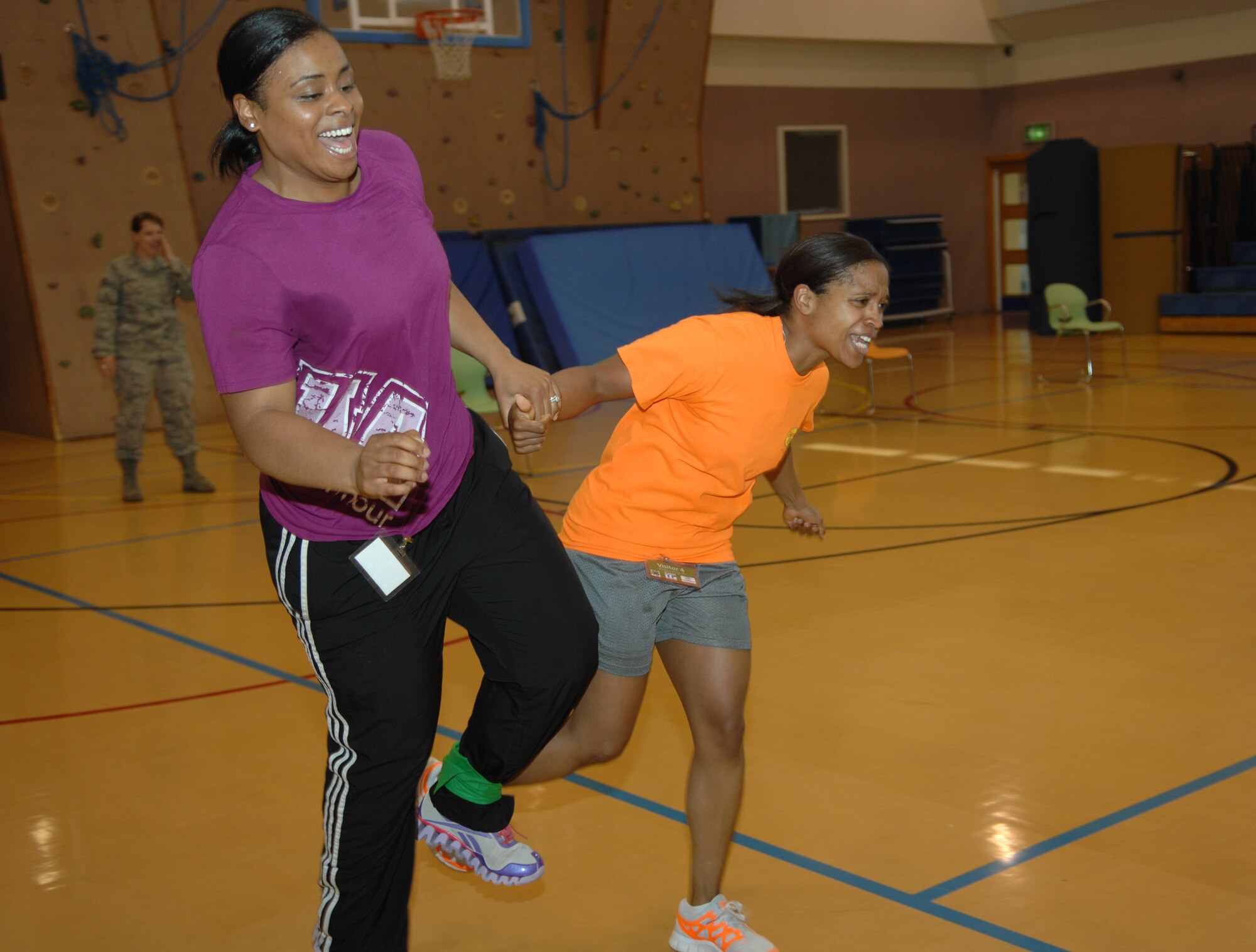 U.S. Air Force Staff Sgt. Lauren Ortega, left, from Brooklyn, N.Y., and U.S. Air Force Tech. Sgt. Ashley Tyler, from Baton Rouge, La., both 100th Security Forces Squadron standardization evaluators, participate in a three-legged race Aug. 26, 2013, as part of a women’s equality celebration at the youth center on RAF Mildenhall, England. Volunteers participated and helped coordinate multiple events for Team Mildenhall children. Children played games, learned about equality and finished the day with an ice cream social. (U.S. Air Force photo by Airman 1st Class Dillon Johnston/Released)