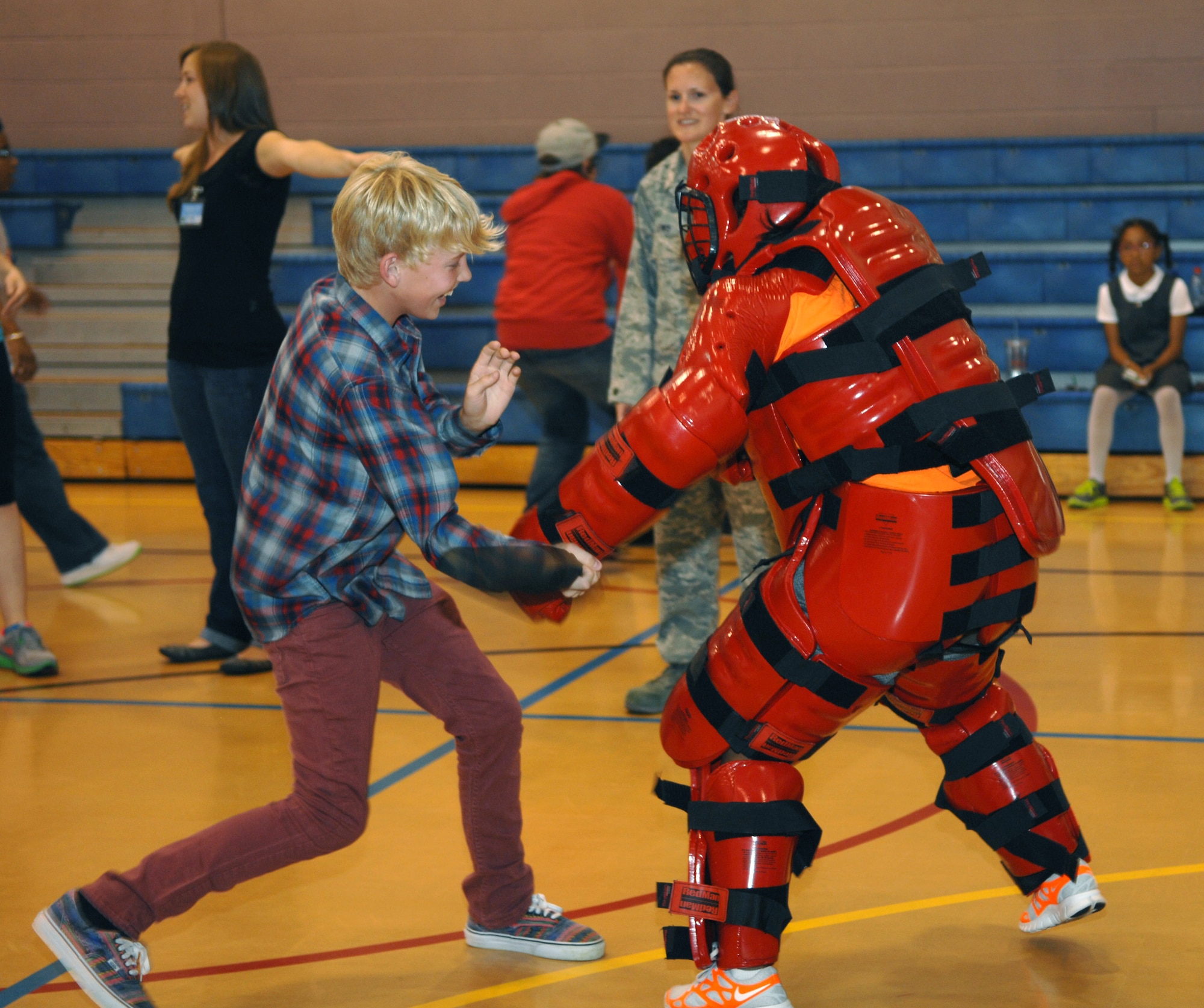 Jordan Milby, left, 13, son of Master Sgt. Christopher Milby, 100th Maintenance Group maintenance training section chief from Carson City, Nev., practices baton techniques on U.S. Air Force Tech. Sgt. Ashley Tyler, 100th Security Forces Squadron standardization evaluator from Baton Rouge, La., Aug. 26, 2013, as part of a women’s equality celebration at the youth center on RAF Mildenhall, England. The 100th SFS members taught children how to properly handle a baton in order to effectively fend off would-be attackers. In celebration of women’s equality, female security forces members suited up and taught combative techniques. (U.S. Air Force photo by Airman 1st Class Dillon Johnston/Released)