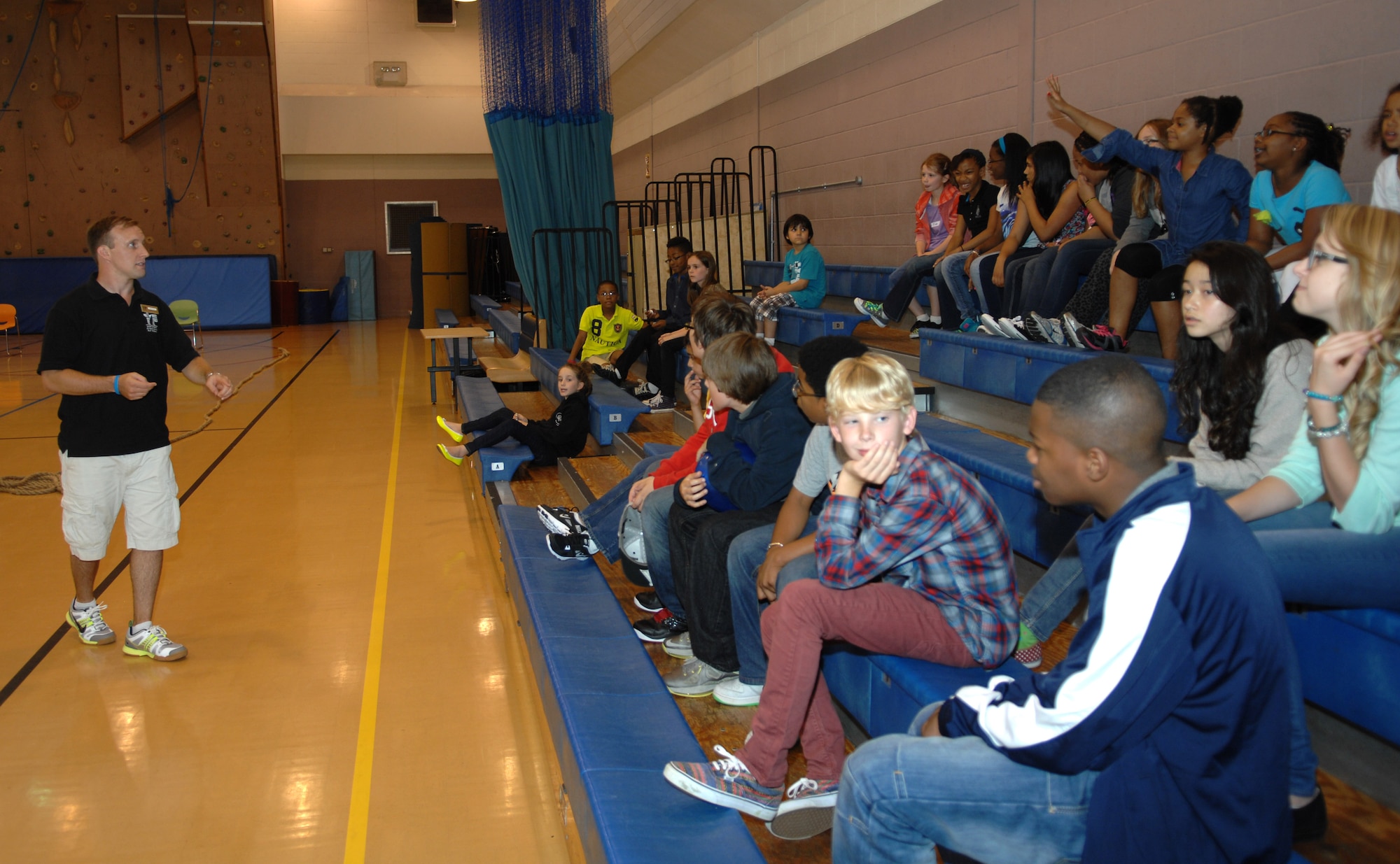 Mathew Kuhl, 100th Force Support Squadron programs coordinator, speaks to Team Mildenhall children about the changes in women’s equality throughout the years Aug. 26, 2013, as part of a women’s equality celebration at the youth center on RAF Mildenhall, England. Service members and civilians volunteered to teach children about women’s equality while engaging in physical activities. In celebration of women’s equality, female security forces members donned protective armor and taught combative techniques.  (U.S. Air Force photo by Airman 1st Class Dillon Johnston/Released)