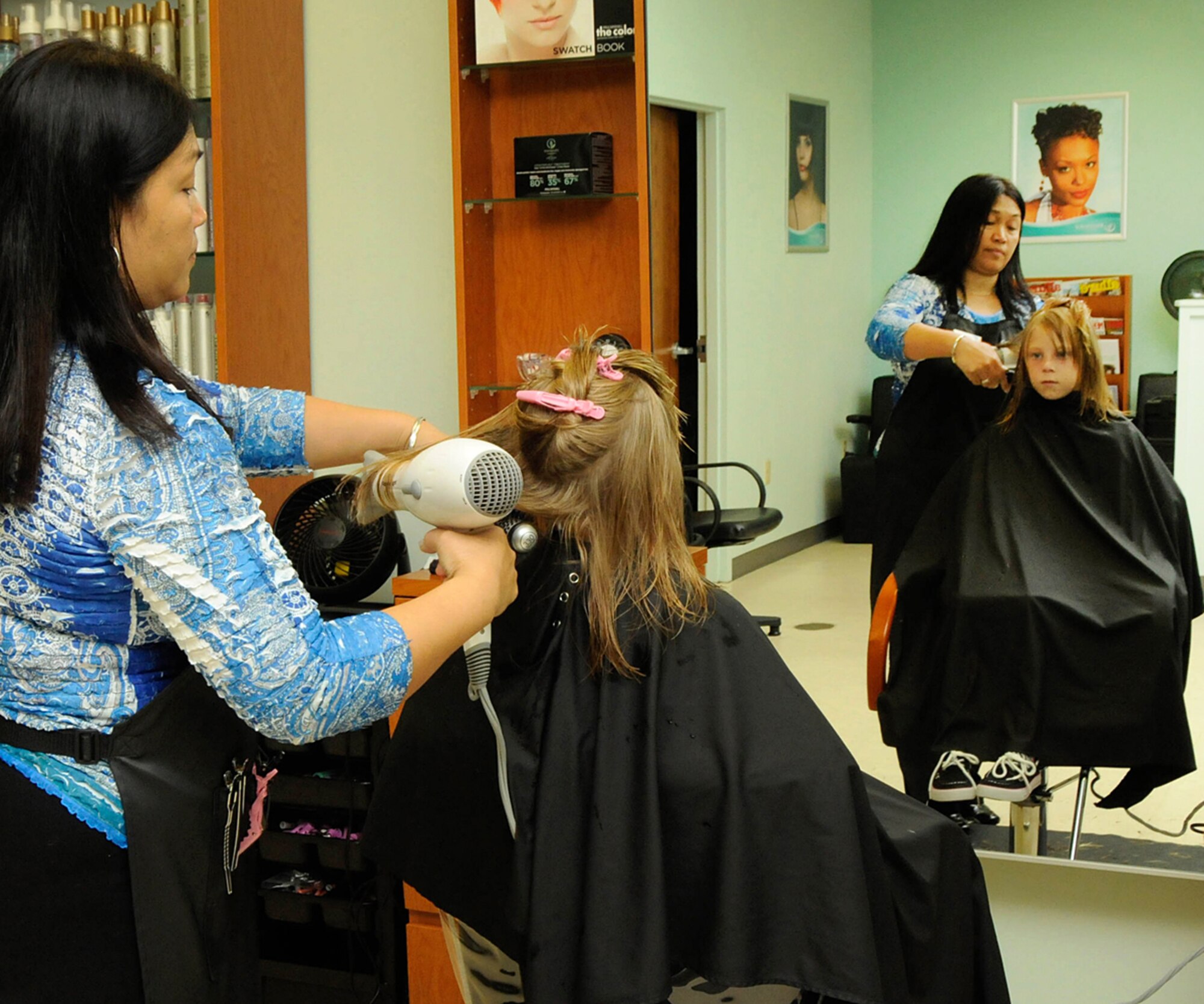 HANSCOM AIR FORCE, Mass. –Virginia Regan, a hair stylist at the Base Exchange Salon, cuts Kasey Reybitzs hair before she heads back to school. Hanscom children in grades first through twelfth head back to school Sept. 3. Pre-school and kindergarten students return Sept. 4. (U.S. Air Force photo by Linda LaBonte Britt)