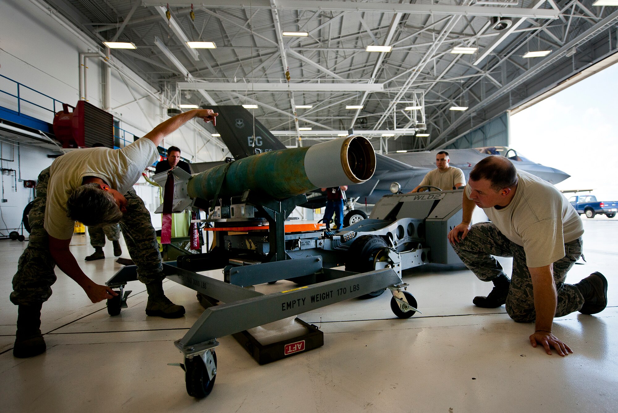 The 33rd Maintenance Group weapons standardization crew returns a guided-bomb-unit-12 to its cradle after loading it onto an F-35A Lightning II Aug. 27 at Eglin Air Force Base, Fla.  This marked the first time Airmen have loaded weapons onto the new joint strike fighter here.  Each step and procedure was analyzed to ensure it was correct or needed to be changed.  The weapons load procedures perfected by the MXG Airmen will be taught to maintenance students in the future.  (U.S. Air Force photo/Samuel King Jr.)