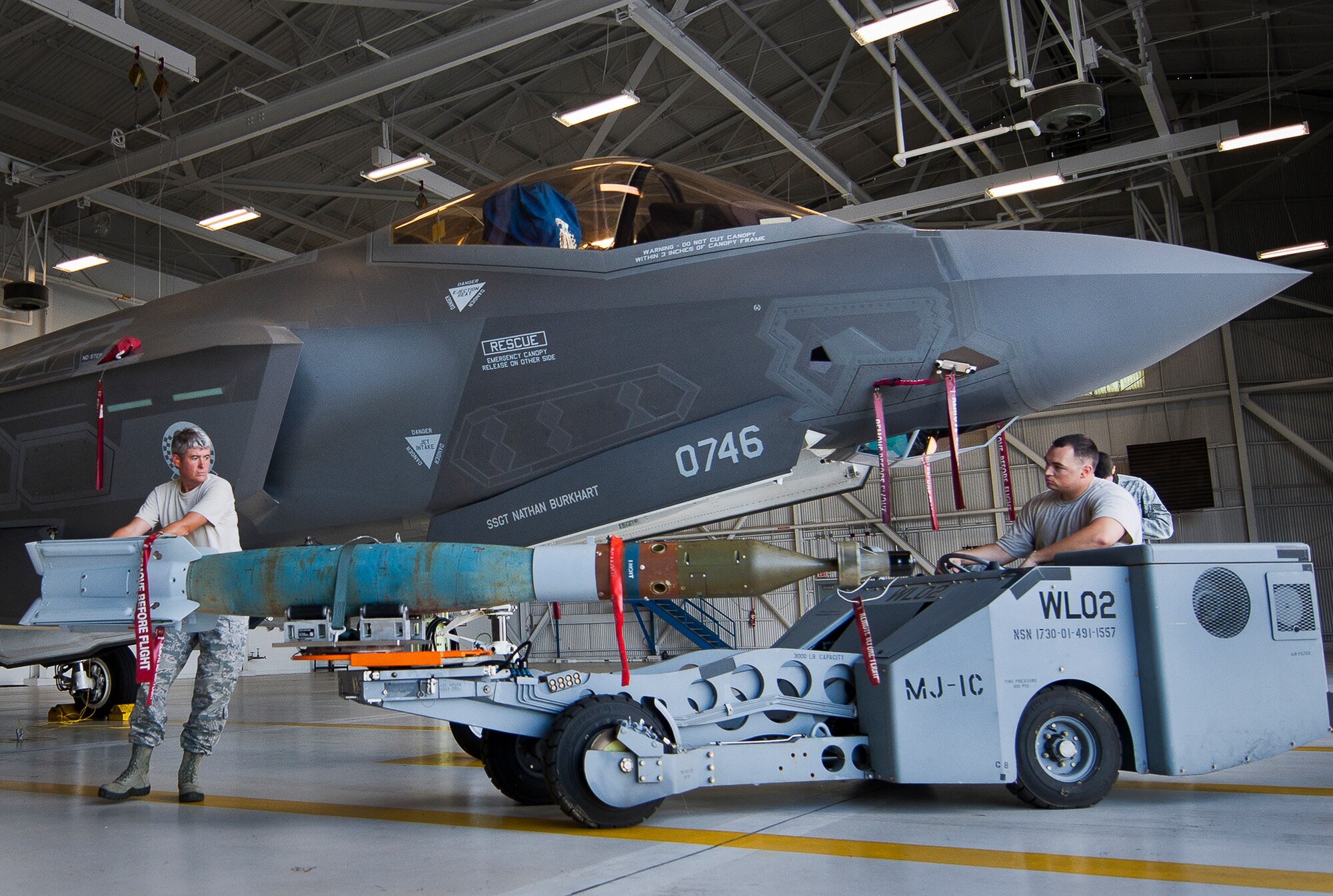 Master Sgt. Karen Griffin, of the 33rd Maintenance Group, maneuvers the guided-bomb-unit-12 into position to be loaded onto an F-35A Lightning II Aug. 27 at Eglin Air Force Base, Fla.  This marked the first time Airmen have loaded weapons onto the new joint strike fighter here.  Each step and procedure was analyzed to ensure it was correct or needed to be changed.  The weapons load procedures perfected by the MXG Airmen will be taught to maintenance students in the future.  (U.S. Air Force photo/Samuel King Jr.)