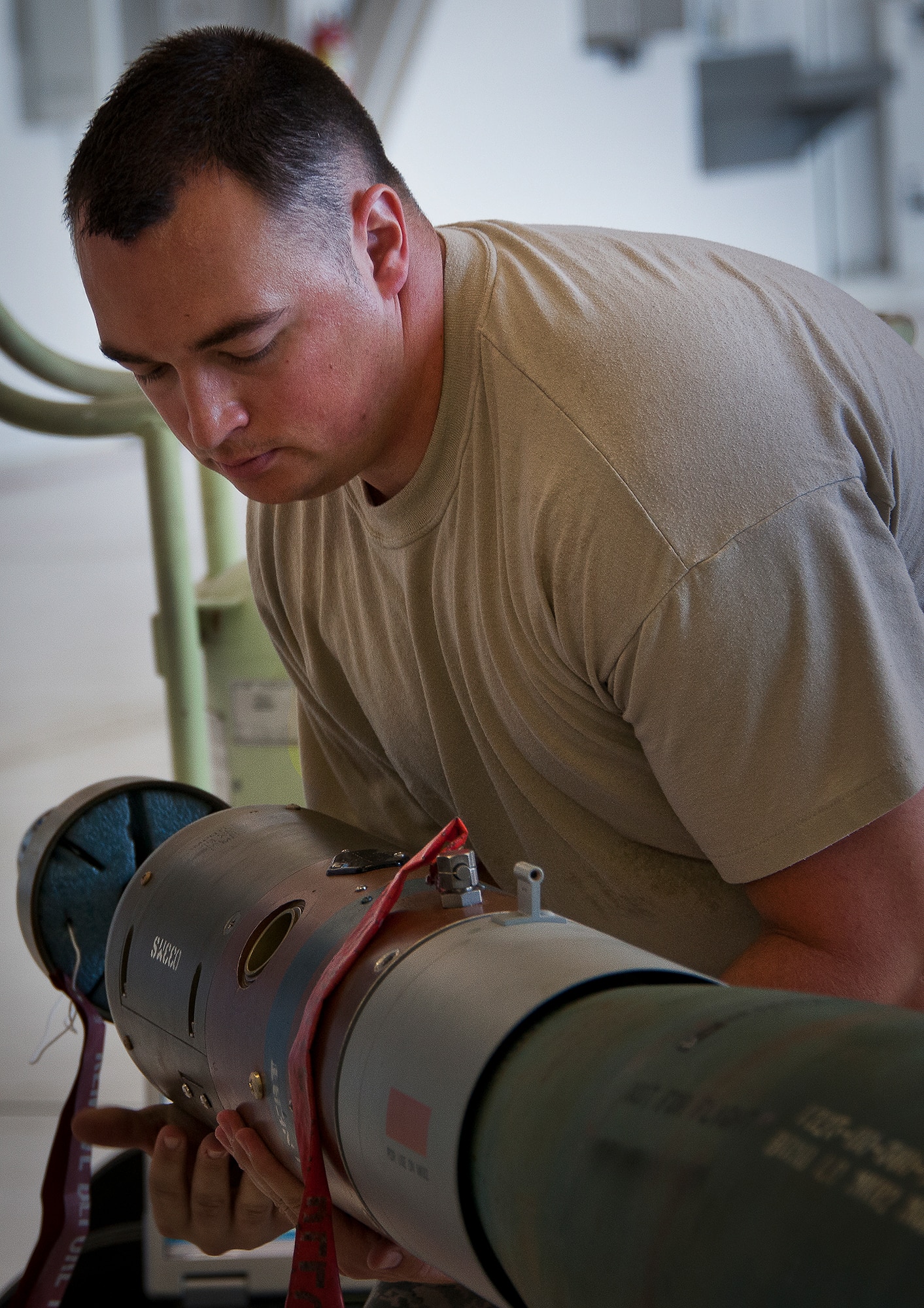 Staff Sgt. Steven Dash, of the 33rd Maintenance Group, places a warhead on the front of a guided-bomb-unit 12 before it’s attached to an F-35A Lightning II Aug. 27 at Eglin Air Force Base, Fla.  This marked the first time Airmen have loaded weapons onto the new joint strike fighter here.  Each step and procedure was analyzed to ensure it was correct or needed to be changed.  The weapons load procedures perfected by the MXG Airmen will be taught to maintenance students in the future.  (U.S. Air Force photo/Samuel King Jr.)