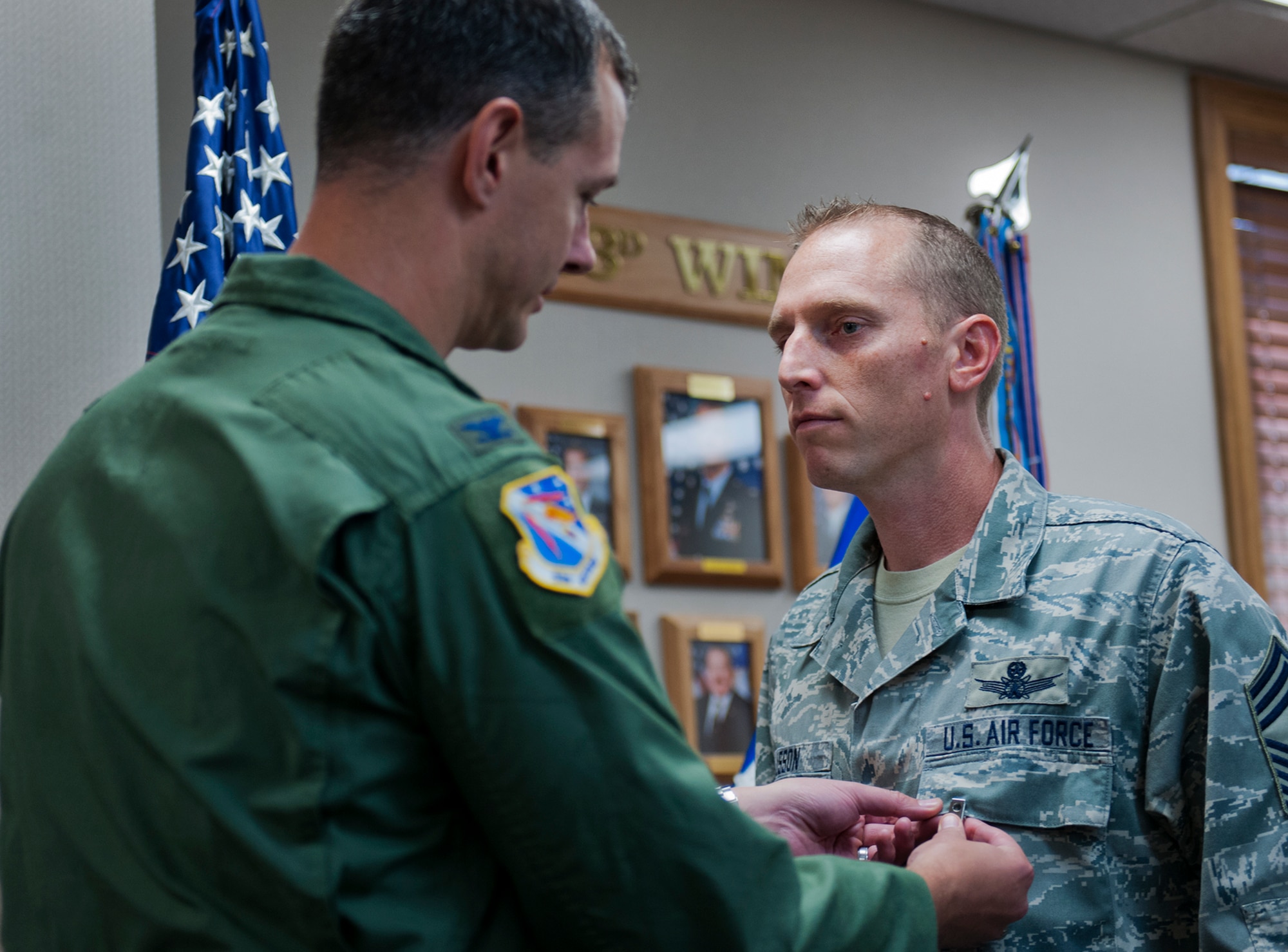 Chief Master Sgt. Matthew Lusson, the 53rd Wing command chief, receives a Bronze Star Medal from Col. Alexus Grynkewich, the 53rd WG commander, Aug. 26 at Eglin Air Force Base, Fla.  The chief received the medal for meritorious achievement as the group superintendent of the 651st Air Expeditionary Group at Camp Bastion Afghanistan.  (U.S. Air Force photo/Samuel King Jr.)