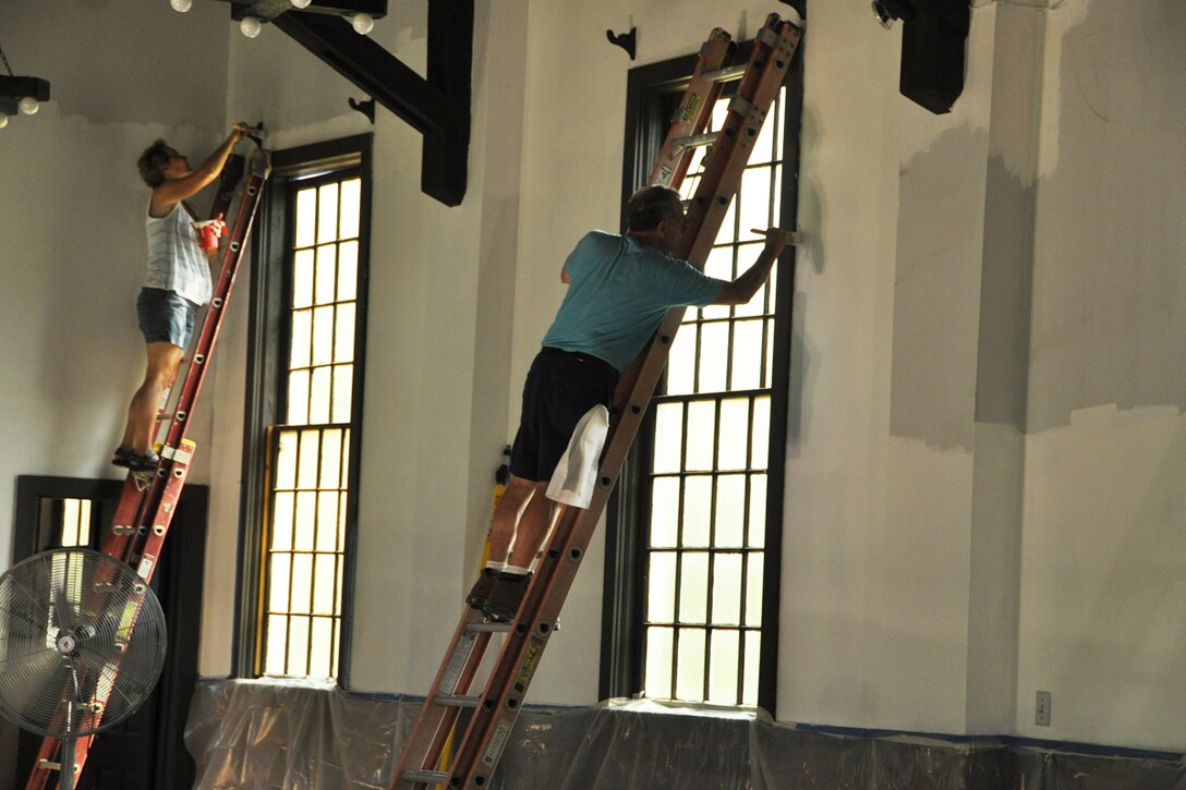 Members of the Dobbins Chapel Foundation, the Covenant Christian Ministies Church and the Episcopal Church of St. Peter and St. Paul Military Ministry paint the walls of the former Dobbins Chapel during Project B.Y.O.B. (Bring Your Own Brush) Aug. 24. The chapel has been ongoing renovation since its move from Dobbins to the Clay National Guard Center March 17.