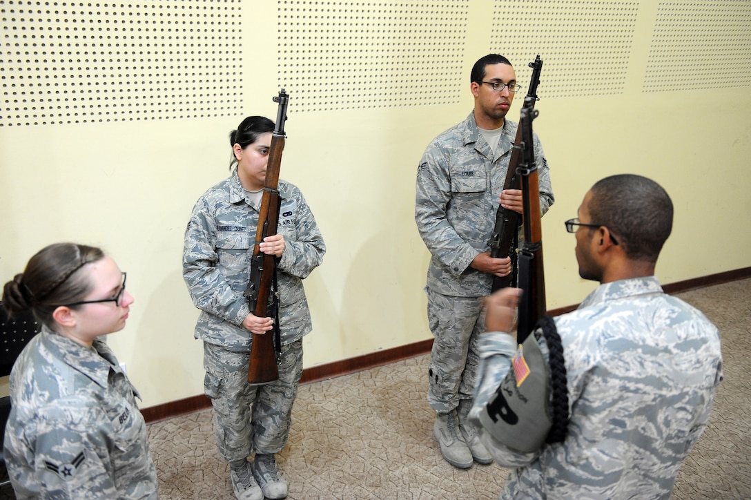 Airman 1st Class Lacey Belen, 386th Expeditionary Force Support Squadron (far left) and Staff Sgt. Bryce Mosley, 386th Expeditionary Civil Engineer Squadron, both aiguillette wearing honor guard members, conduct rifle training during honor guard practice at an undisclosed location in Southwest Asia Aug. 27, 2013.  The 386th Air Expeditionary Wing Honor Guard currently has about 30 members, 12 of whom are aiguillette wearers.  Members who wear the aiguillette are experienced honor guard members working toward the honor guard brassard.  Aiguillette wearers are used as trainers for the newer members of the team.  (U.S. Air Force photo by Master Sgt. Marelise Wood)
