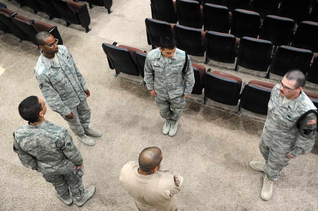 Senior Airman Christopher Hernandez, 386th Expeditionary Force Support Squadron (center) and Airman 1st Class Samuel Hancock, 386th Expeditionary Civil Engineer Squadron (far right), honor guard aiguillette wearers, train new members in honor guard movements during honor guard practice at an undisclosed location in Southwest Asia Aug. 27, 2013.  The 386th Air Expeditionary Wing Honor Guard currently has about 30 members, 12 of whom are aiguillette wearers.  Members who wear the aiguillette are experienced honor guard members working toward the honor guard brassard.  Aiguillette wearers are used as trainers for the newer members of the team.  (U.S. Air Force photo by Master Sgt. Marelise Wood) 