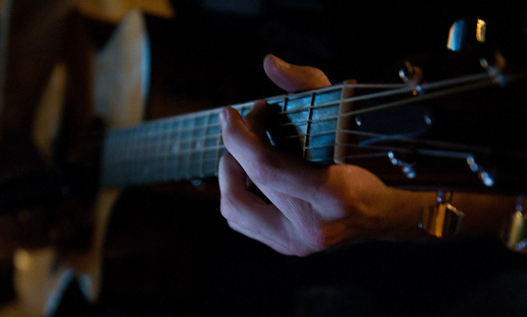 Fingers glide across the fret board of a guitar during open mic night Aug. 6, 2013, at Incirlik Air Base, Turkey. Open mic occurs outside the Incirlik club complex and allows Team Incirlik members to showcase various talents. (U.S. Air Force photo by Senior Airman Daniel Phelps/Released)