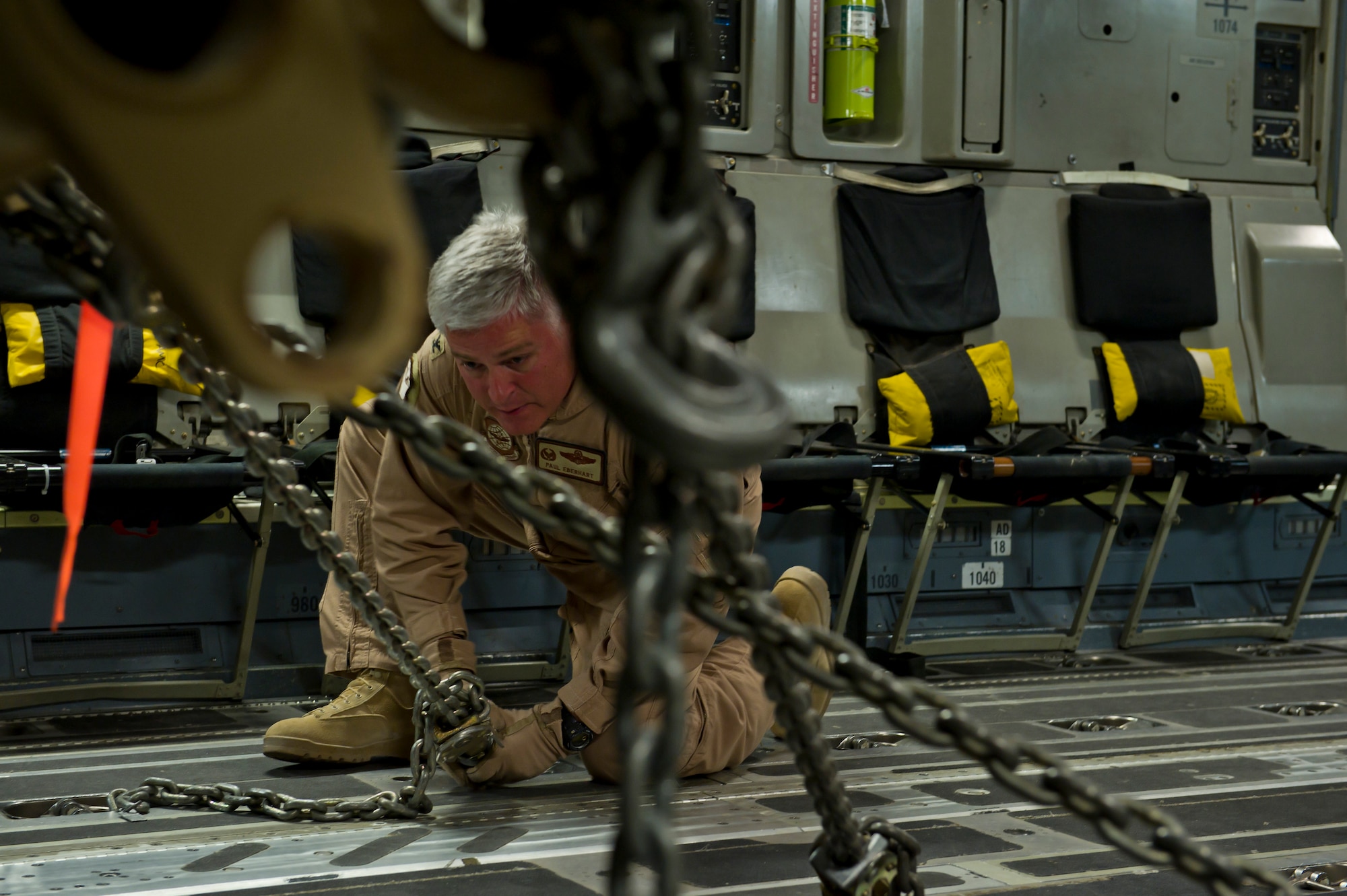 U.S. Air Force Col. Paul Eberhart, 316th Expeditionary Airlift Squadron commander, straps down a mine resistant ambush protected vehicle onto a C-17 during an airlift mission, July 26, 2013, Kandahar Air Field, Afghanistan. The C-17 is capable of rapid strategic and tactical delivery of troops and any type of cargo around the Central Command area of reasonability. The aircraft can perform airlift, airdrop, and transport ambulatory patients during aeromedical evacuations when required. (U.S. Air Force photo/Staff Sgt. Marleah Miller)