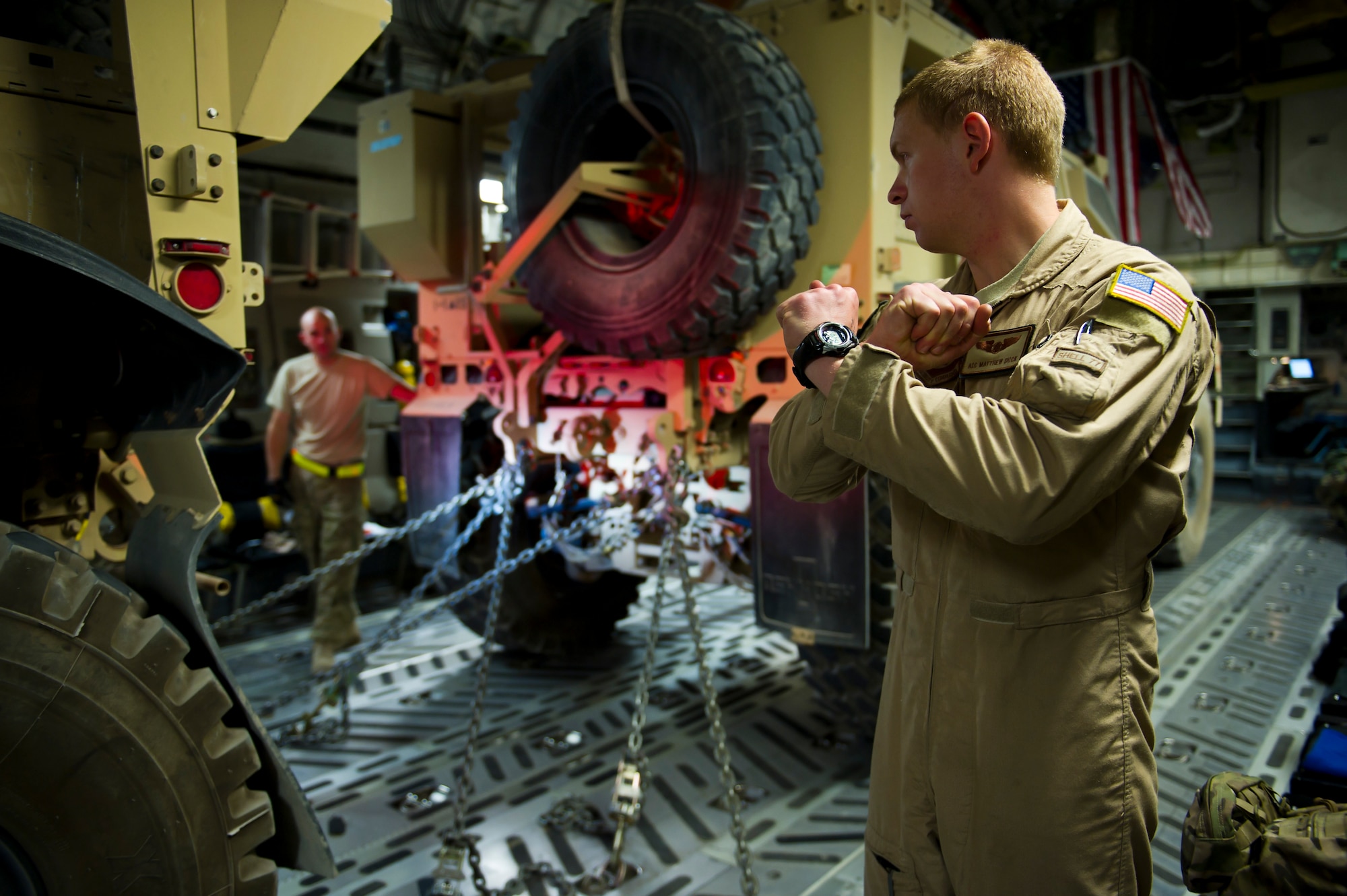 U.S. Air Force Airman 1st Class Matthew Duck, 316th Expeditionary Airlift Squadron C-17 Globemaster III loadmaster, prepares to direct the driver of a mine resistant ambush protected vehicle onto a C-17 during an airlift mission, July 26, 2013, Kandahar Air Field, Afghanistan. The C-17 is capable of rapid strategic and tactical delivery of troops and any type of cargo around the Central Command area of reasonability. The aircraft can perform airlift, airdrop, and transport ambulatory patients during aeromedical evacuations when required. (U.S. Air Force photo/Staff Sgt. Marleah Miller)
