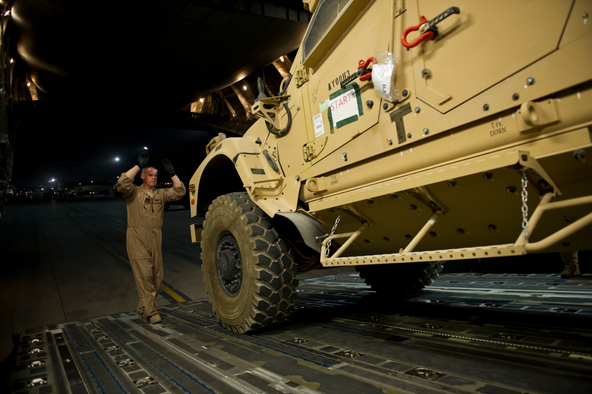 U.S. Tech. Sgt. Gary Washington, 316th Expeditionary Airlift Squadron C-17 Globemaster III loadmaster, directs the driver of a mine resistant ambush protected vehicle onto a C-17 during an airlift mission, July 26, 2013, Kandahar Air Field, Afghanistan. The C-17 is capable of rapid strategic and tactical delivery of troops and any type of cargo around the Central Command area of reasonability. The aircraft can perform airlift, airdrop, and transport ambulatory patients during aeromedical evacuations when required. (U.S. Air Force photo/Staff Sgt. Marleah Miller)