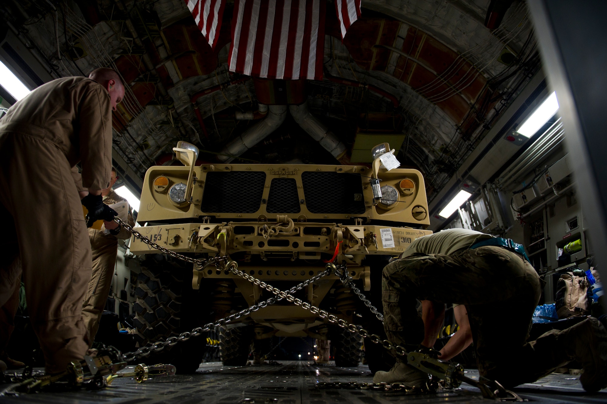 Members from the 316th Expeditionary Airlift Squadron, load military vehicles on to a C-17 Globemaster III during an airlift mission, July 26, 2013, Kandahar Air Field, Afghanistan. The C-17 is capable of rapid strategic and tactical delivery of troops and any type of cargo around the Central Command area of reasonability. The aircraft can perform airlift, airdrop, and transport ambulatory patients during aeromedical evacuations when required. (U.S. Air Force photo/Staff Sgt. Marleah Miller)