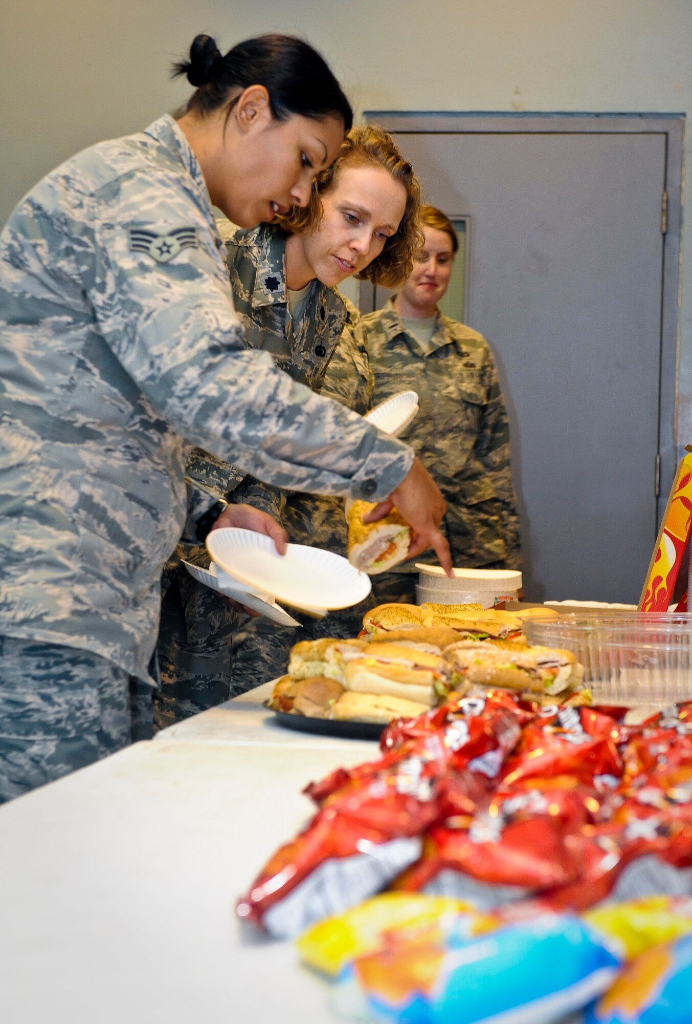 Senior Airman Vikki Flores and Lt. Col. Sirena Morris select which sandwich to eat during the Women?s Equality Day celebration at the 379th Air Expeditionary Wing in Southwest Asia, Aug. 26, 2013. Flores is a 379th Expeditionary Civil Engineer Squadron emergency management journeyman deployed from Dover Air Force Base, Del., and an Azusa, Calif., native. Morris is the 379th Expeditionary Force Support Squadron commander and a Fayetteville, N.C., native. (U.S. Air Force photo/Senior Airman Benjamin Stratton)