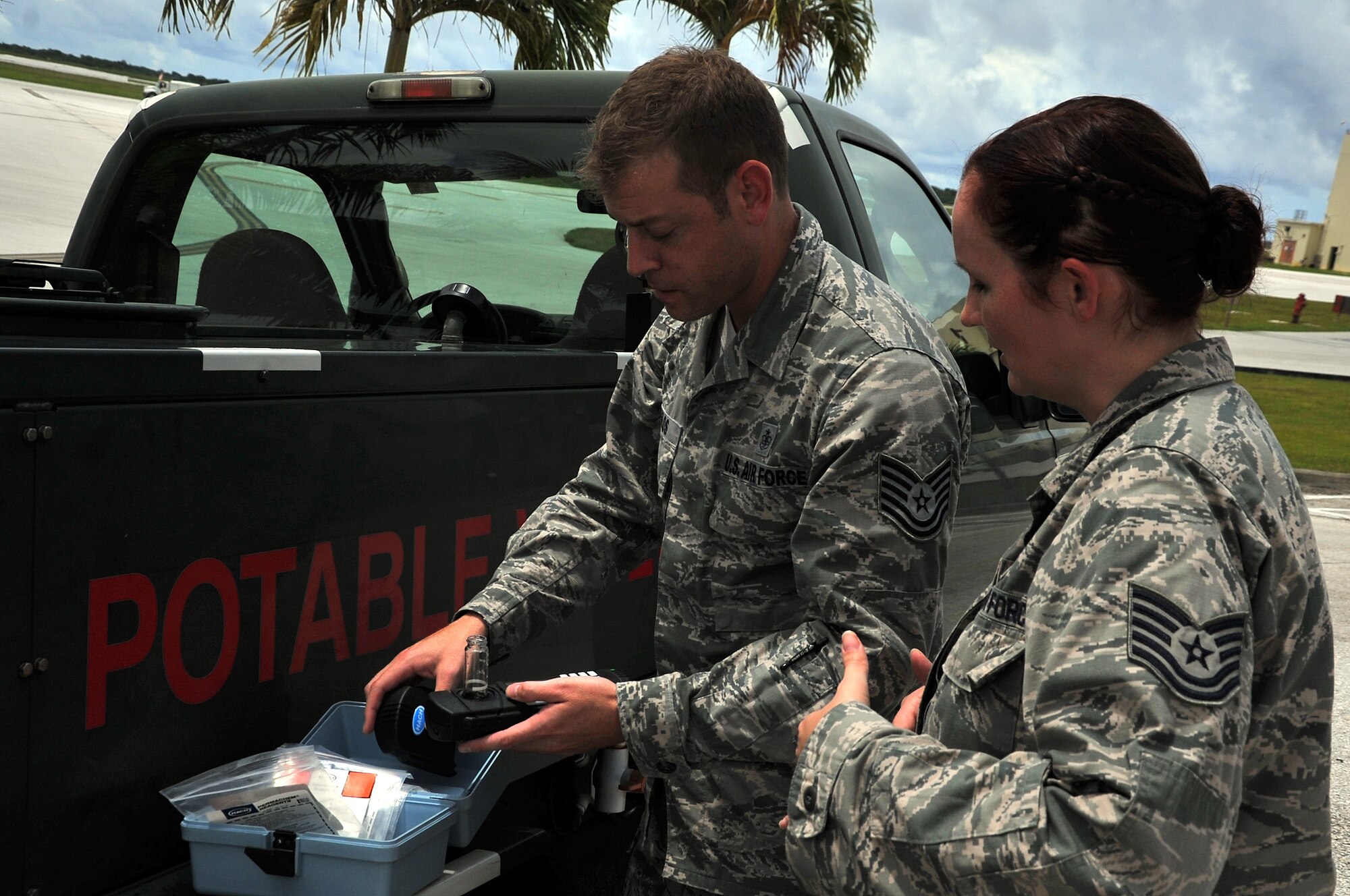 Tech. Sgt. Marcus Poulos, 36th Medical Operations Squadron Bioenvironmental Flight environmental NCO in charge, and Tech. Sgt. Richelle Rodriguez, 36th MDOS ambulance services NCOIC, test the pH level of a water sample taken from a potable water transport truck Aug. 22, 2013, on Andersen Air Force Base, Guam. Eight randomly selected drinking water outlets on base are tested by the bioenvironmental Airmen at least once per month. (U.S. Air Force photo by Staff Sgt. Melissa B. White/Released)