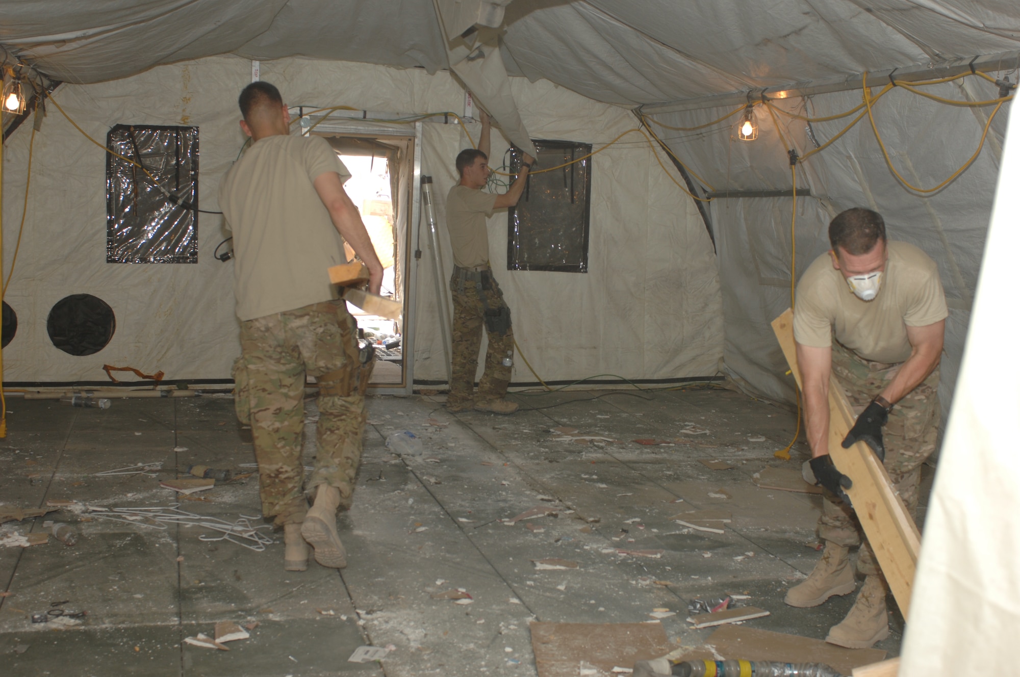 Airmen from the 451st Air Expeditionary Wing clean out a tent at Camp Samek, Kandahar Airfield, Afghanistan, Aug. 22, 2013. Space is being cleared at Camp Samek so that 451st AEW operations can consolidate into fewer camps at KAF as Airmen began retrograde operations. (U.S. Air Force photo by Senior Airman Jack Sanders)