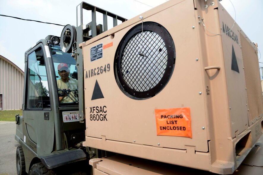 U.S. Air Force Senior Airman Ronnie Nera, 254th  RED HORSE Squadron heavy equipment operator, lifts an environmental climate unit at Rush Park, Osan Air Base, Republic of Korea, during the Ulchi Freedom Guardian 2013 exercise, Aug. 18, 2013. The 254th RHS currently sustains the bare base at Rush Park to include 24 tents, 10 ConEx's, two K-spans, one lodging facility and morale services. UFG is an annual training, defense-oriented exercise developed around realistic scenarios designed to defend the ROK, protect the region, and maintain stability on the Korean Peninsula. (U.S. Air Force photo/Staff Sgt. Sheila deVera)

