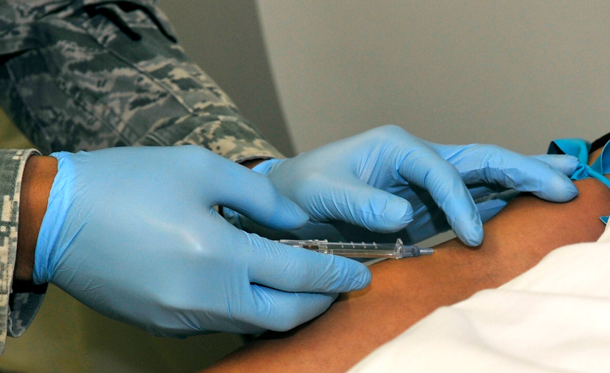 U.S. Air Force Staff Sgt. Mark Lagman, 35th Surgical Operations Squadron diagnostic imaging technologist, places an IV into a patient’s arm before a CT scan at Misawa Air Base, Japan, Aug. 27, 2013. A CT scan allows Airmen of the diagnostic imaging flight to quickly access a health assessment of a patient within a matter of minutes. (U.S. Air Force photo by Airman 1st Class Zachary Kee)