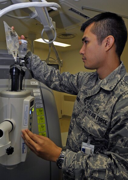 U.S. Air Force Senior Airman James Lord, 35th Surgical Operations Squadron diagnostic imaging technologist, prepares an IV for a CT scan with contrast at Misawa Air Base, Japan, Aug. 27, 2013. Prior to a CT scan with contrast, technologists prepare an IV with IV contrast and saline solution. The IV contrast makes blood vessels appear more prominent and better allows radiologists to check for health concerns. (U.S. Air Force photo by Airman 1st Class Zachary Kee) 