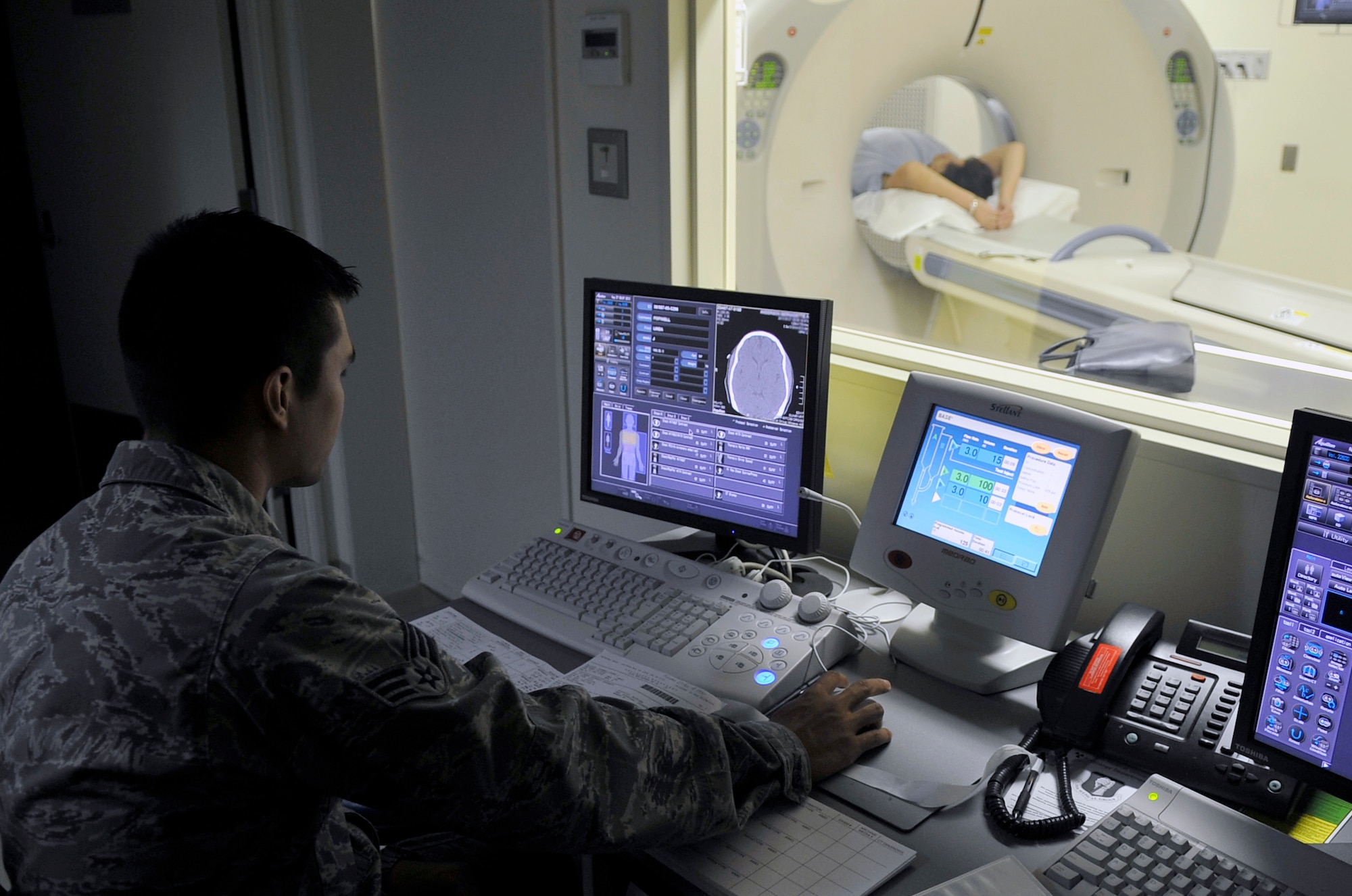 U.S. Air Force Senior Airman James Lord, 35th Surgical Operations Squadron diagnostic imaging technologist, starts a CT scan at Misawa Air Base, Japan, Aug. 27, 2013. With this monitor, technologists can start and control a scan without being in the same room as the patient or machine. (U.S. Air Force photo by Airman 1st Class Zachary Kee)