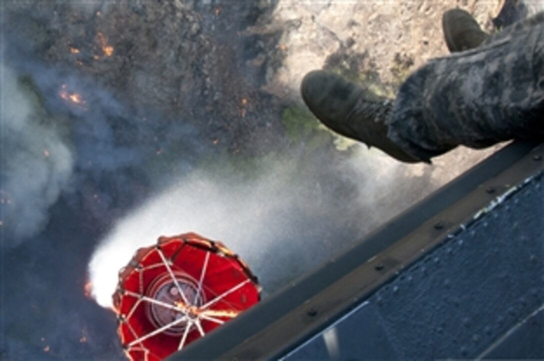 Soldiers in a UH-60 Black Hawk helicopter drop water as they battle the Rim fire at Yosemite National Park, Calif., Aug. 23, 2013. The soldiers are assigned to 1st Battalion, 140th Aviation Regiment, California Army National Guard.