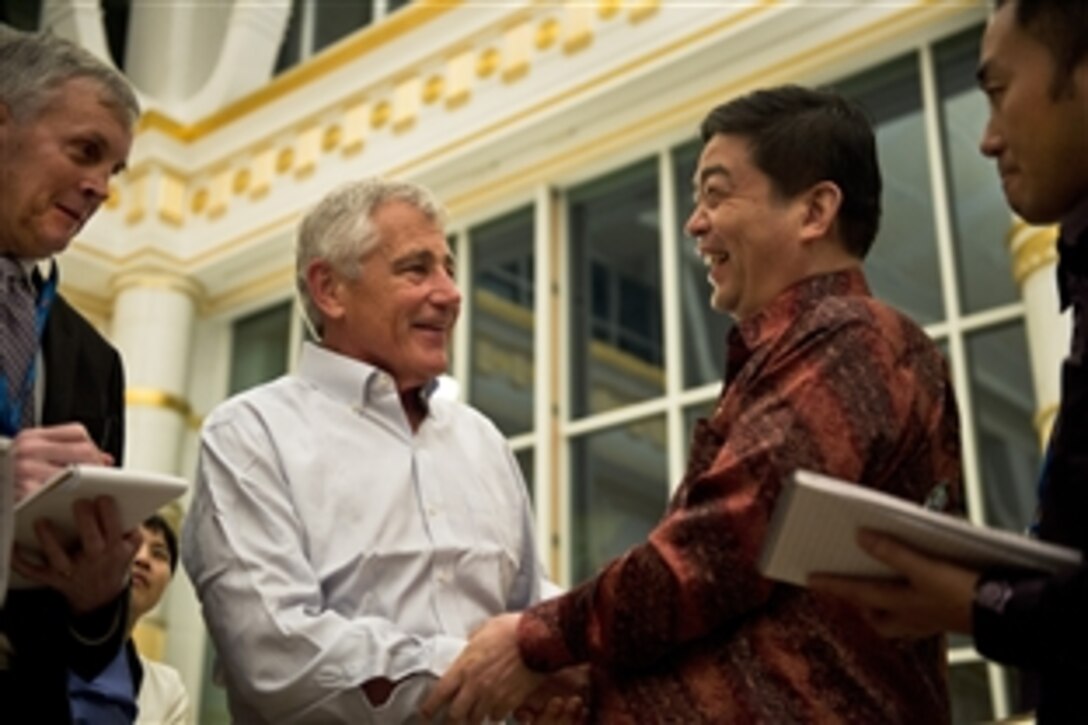 U.S. Defense Secretary Chuck Hagel, left, shares a light moment with Chinese Defense Minister Gen. Chang Wanquan at the Empire Hotel in Jerudong, Brunei, Aug. 28, 2013. 
