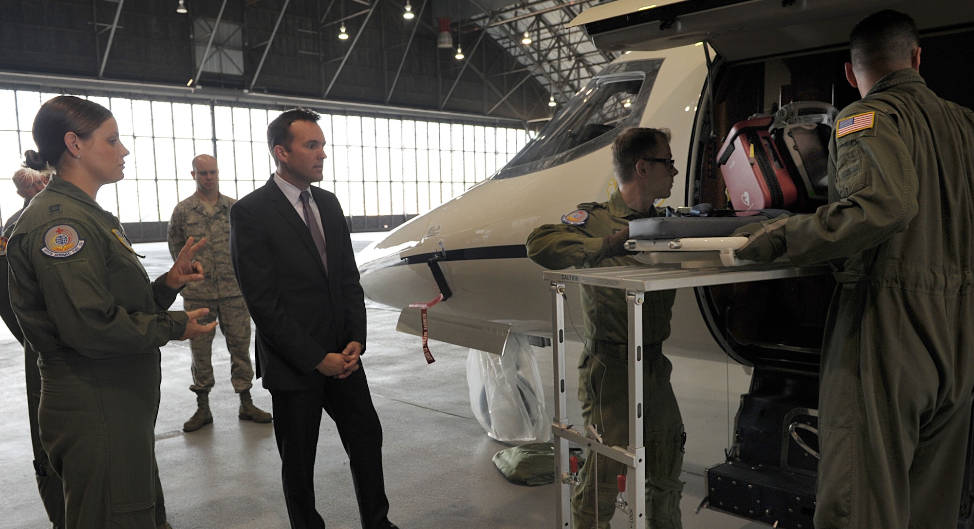 Acting Secretary of the Air Force Eric Fanning watches Airmen demonstrate how to put a stretcher inside a C-21 during a tour of Scott Air Force Base, Ill., Aug. 22, 2013. At each stop, Fanning spoke with dozens of Airmen and civilians, gaining insight on how they support the airlift mission and listening to their concerns. 