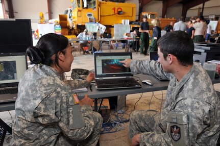 Colorado Army National Guard Sgt. Cassandra Quinones listens as Sgt. Nathan Faith, both with the 117th Space Battalion, points out areas on an inferred satellite image of the West Fork Complex Fire from their location in Pagosa Springs Colo., June 27, 2013. The West Fork Complex Fire is in the Rio Grande National Forest, Colo., and Colorado National Guard's soldiers and airmen have been assisting local authorities.