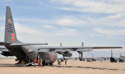 An air tanker "pit" crew detaches a fire retardant loading hose from an Air Force Reserve C-130 June 24, 2013, prior to the aircraft's departure from Peterson Air Force Base, Colo.