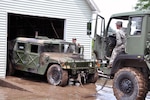New York Army National Guard Soldiers Staff Sgt. Gary Matt from the 2nd Battalion 108th Infanty and Staff Sgt. Joe Bolton from the 206th Military Police Company tow a surplus Humvee used by the Village of Mohawk as a rescue vehicle out of a garage where it was submerged in five feet of water.