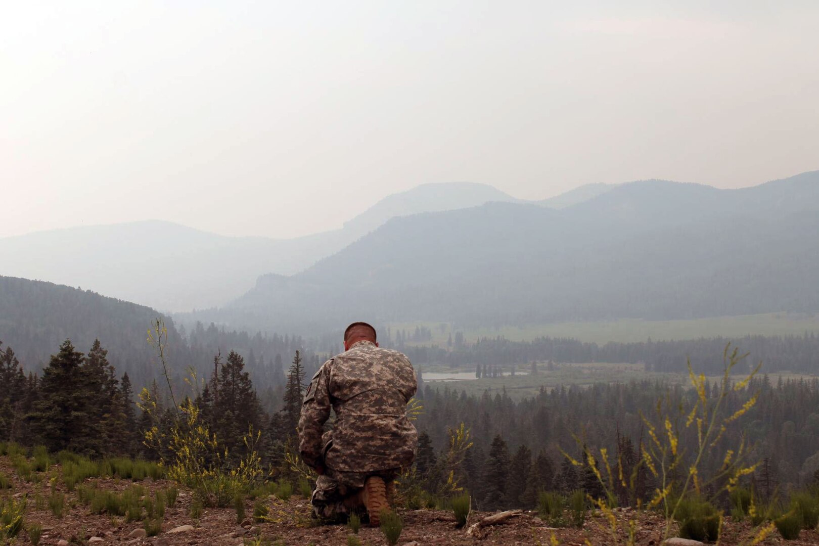 First Lt. Justin Cowan, chaplain, prays during a visit to Guard members in the area of West Fork Complex fire Colorado National Guard operations, June 30, 2013.