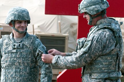 Col. Douglas Fleischfresser, Wisconsin Army National Guard state command chaplain, places the 32nd Infantry Brigade Combat Team unit patch on 1st Lt. Christopher Mohr during a July 10 ceremony at Fort McCoy, Wis.