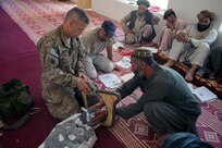 U.S. Army Maj. Eugene Johnson, a veterinarian with Georgia Agricultural Development Team 3, Regimental Combat Team 7, explains how to aid livestock with birthing problems during veterinary classes in Kajaki District, April 24, 2013.