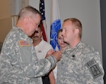 New York Army National Guard Sgt. Joshua Young, a member of the 1108th Ordnance Company (Explosive Ordnance Disposal), receives the Bronze Star with V device for valor during a ceremony at the Scotia-Glenville, N.Y., Armed Forces Reserve Center, July 19, 2013.