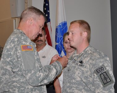 New York Army National Guard Sgt. Joshua Young, a member of the 1108th Ordnance Company (Explosive Ordnance Disposal), receives the Bronze Star with V device for valor during a ceremony at the Scotia-Glenville, N.Y., Armed Forces Reserve Center, July 19, 2013.