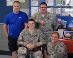 Army Staff Sgt. Ciara Riley, lower right, Devin Sutherland, lower left, Sgt. 1st Class Stewart Stevens, right, Steven Sutherland, Devin's father, left, at North Carolina National Guard Army Readiness Center in Winston-Salem, N.C. Stevens and Riley, both North Carolina National Guard soldiers, and many others joined together to make Devin Sutherland a 'Soldier for the Day.'