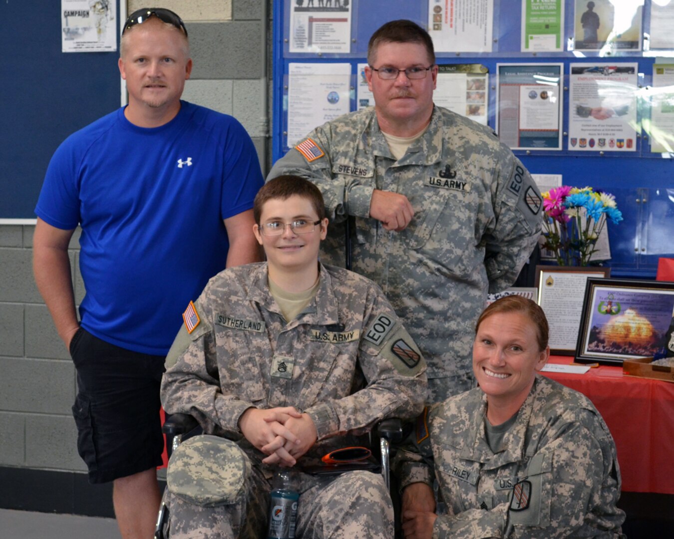 Army Staff Sgt. Ciara Riley, lower right, Devin Sutherland, lower left, Sgt. 1st Class Stewart Stevens, right, Steven Sutherland, Devin's father, left, at North Carolina National Guard Army Readiness Center in Winston-Salem, N.C. Stevens and Riley, both North Carolina National Guard soldiers, and many others joined together to make Devin Sutherland a 'Soldier for the Day.'