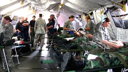 Airmen from the 139th Aeromedical Evacuation Squadron of the 109th Airlift Wing, while working with civilian agencies, provide treatment during an exercise to simulated patients, Civil Air Patrol cadets, after they were brought to the base from the Aplaus Fire Department, Aug. 8, 2013.