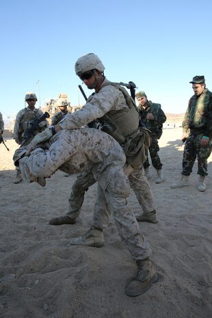 MARINE CORPS AIR GROUND COMBAT CENTER TWENTYNINE PALMS, Calif. – Corporal Joshua Burton, rifleman, 3rd Battalion, 7th Marine Regiment, demonstrates how to properly handle a detainee during the Integrated Training Exercise here, Aug. 12, 2013. Burton, 21, a native of Bakerville, Calif., said this type of training is essential because it shows Marines how to teach the proper way to handle detainees to the Afghan National Army. The Marines assume a supporting role while deployed to Afghanistan by letting the ANA and the Afghan National Police lead in combat operations. The ITX is a training exercise held to prepare Marines prior to their upcoming deployment to Afghanistan.