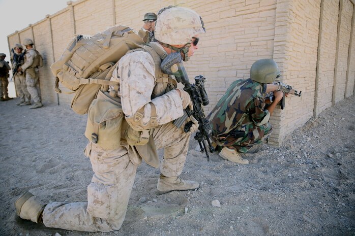MARINE CORPS AIR GROUND COMBAT CENTER TWENTYNINE PALMS, Calif. – Private First Class Cody Frisosky (left), rifleman, 3rd Battalion, 7th Marine Regiment, prepares to rush across a street while a role-player acting as an Afghan National Army solider provides suppressing fire during the Integrated Training Exercise here, Aug. 12, 2013. Frisosky, 19, a native of Shippensburg, Penn., and his team supported the main push into the mock town. The Marines assume a supporting role while deployed to Afghanistan by letting the ANA and the Afghan National Police lead in combat operations. The ITX is a training exercise held to prepare Marines prior to their upcoming deployment to Afghanistan.