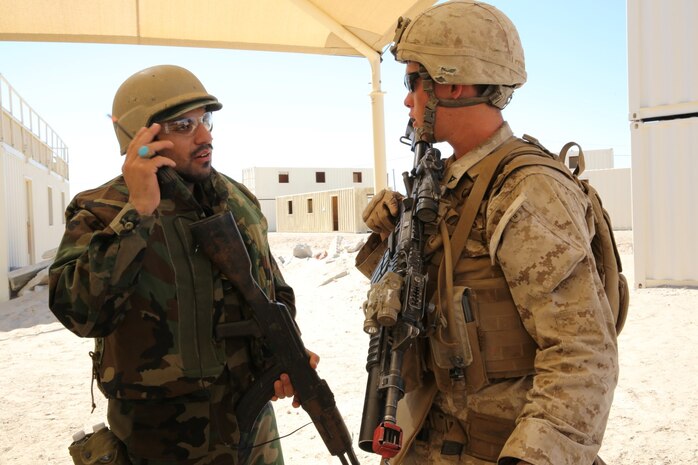 MARINE CORPS AIR GROUND COMBAT CENTER TWENTYNINE PALMS, Calif. – Lance Cpl. Jared Edwards (right), a team leader, 3rd Battalion, 7th Marine Regiment, talks to a role-player acting as an Afghan National Army soldier while conducting a mock raid during the Integrated Training Exercise here, Aug. 12, 2013. Edwards, 21, a native of Arvada, Colo., speaks Pashtu, which enables him to communicate with the role-players. The Marines assume a supporting role while deployed to Afghanistan by letting the ANA and the Afghan National Police lead in combat operations. The ITX is a training exercise held to prepare Marines prior to their upcoming deployment to Afghanistan.