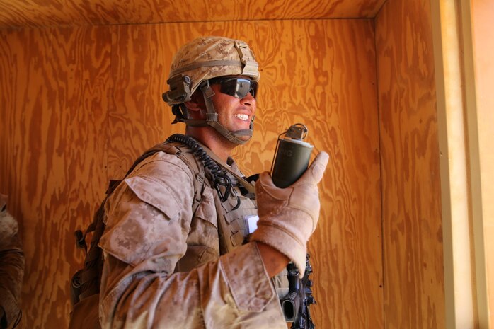 MARINE CORPS AIR GROUND COMBAT CENTER TWENTYNINE PALMS, Calif. – Corporal Miles Potter, squad leader, 3rd Battalion, 7th Marine Regiment, prepares to throw an M18 smoke grenade to mark an enemy role-player’s location while conducting a mock raid during the Integrated Training Exercise here, Aug. 12, 2013. Potter, 25, a native of  Riverside, Calif., and his squad were in charge of securing the area to ensure the priority targets did not escape. The Marines assume a supporting role while deployed to Afghanistan by letting the ANA and the Afghan National Police lead in combat operations. The ITX is a training exercise held to prepare Marines prior to their upcoming deployment to Afghanistan.